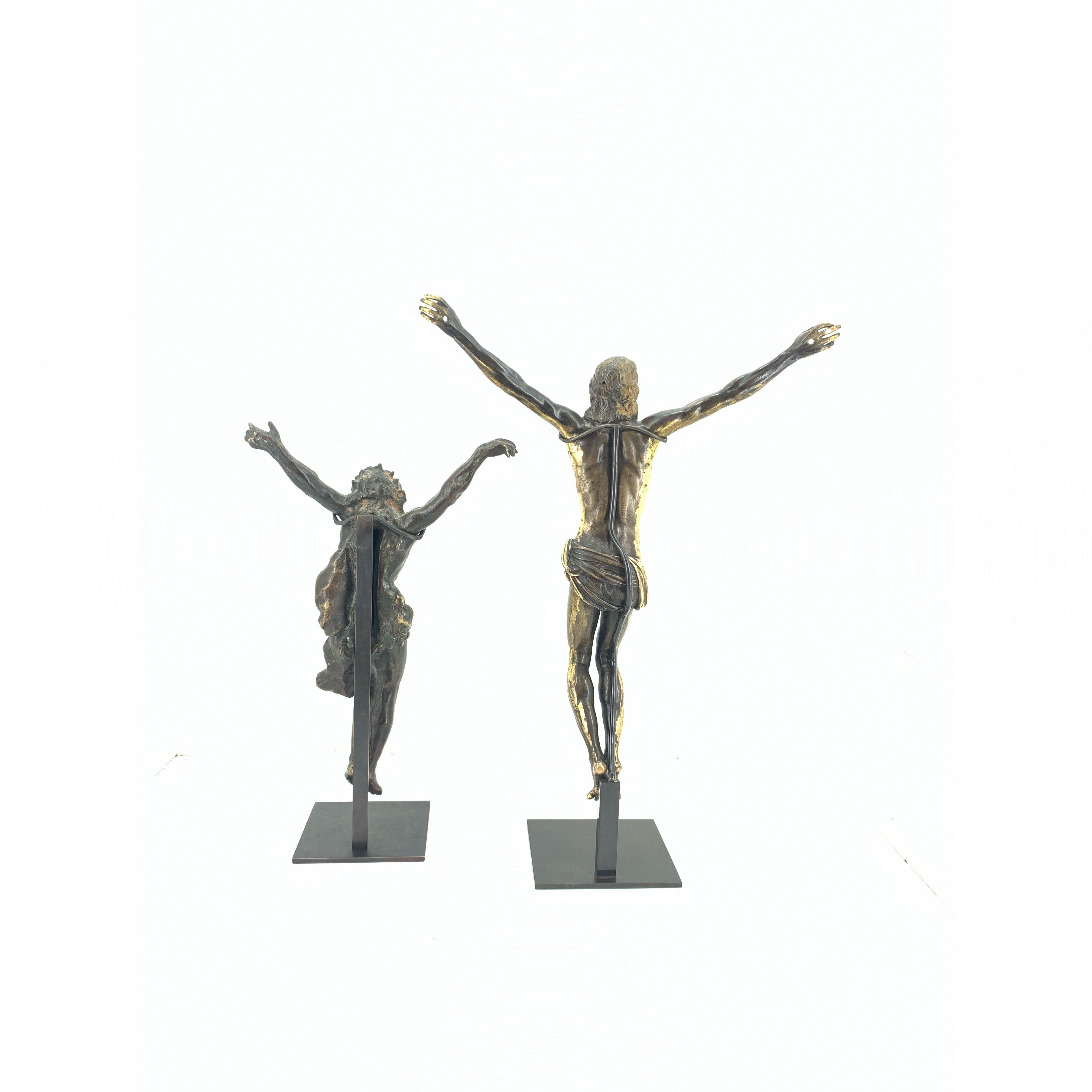 deux christs de dos sur des socles en acier noir sur fond blanc 