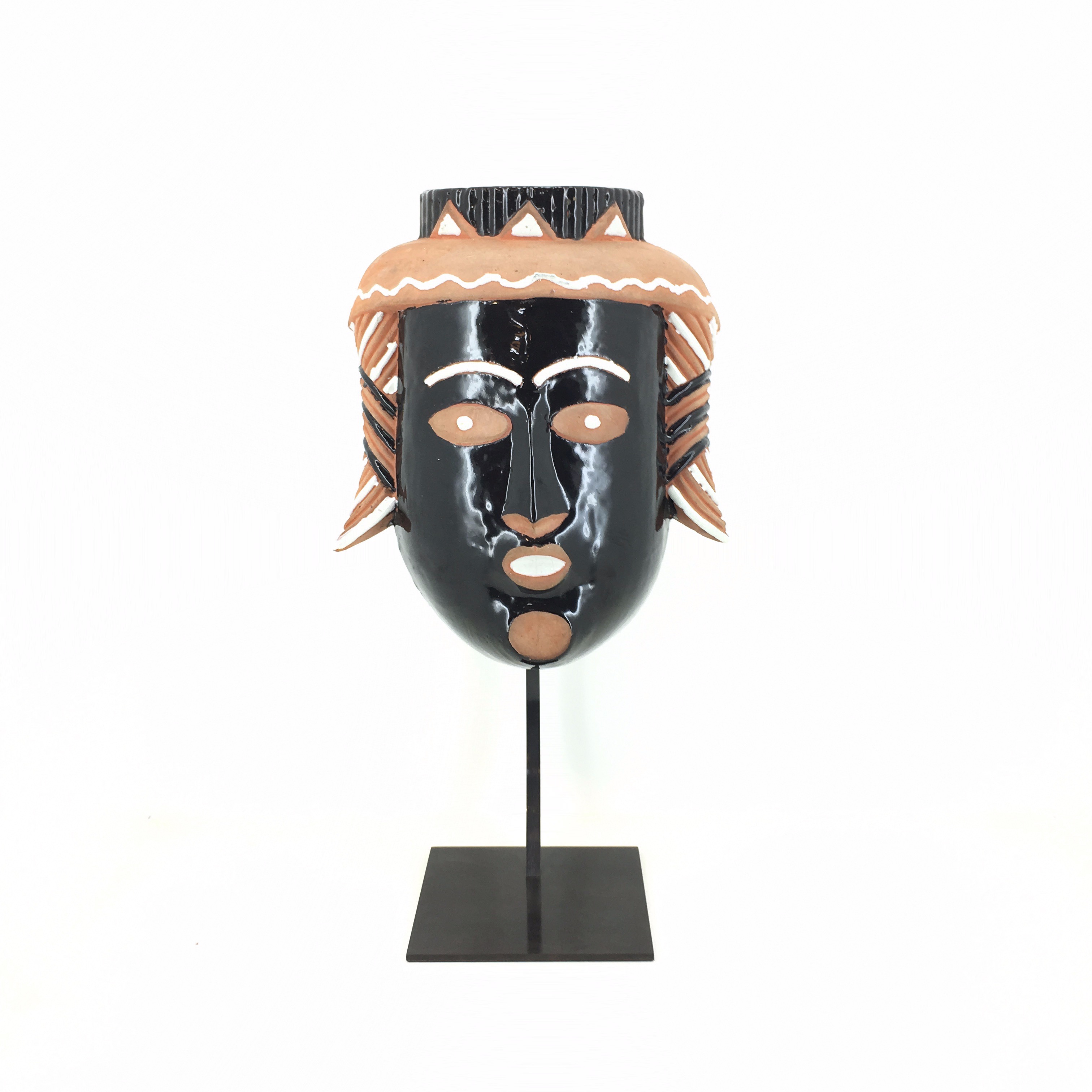 masque en cramique peint sur un socle en acier noir sur fond blanc 