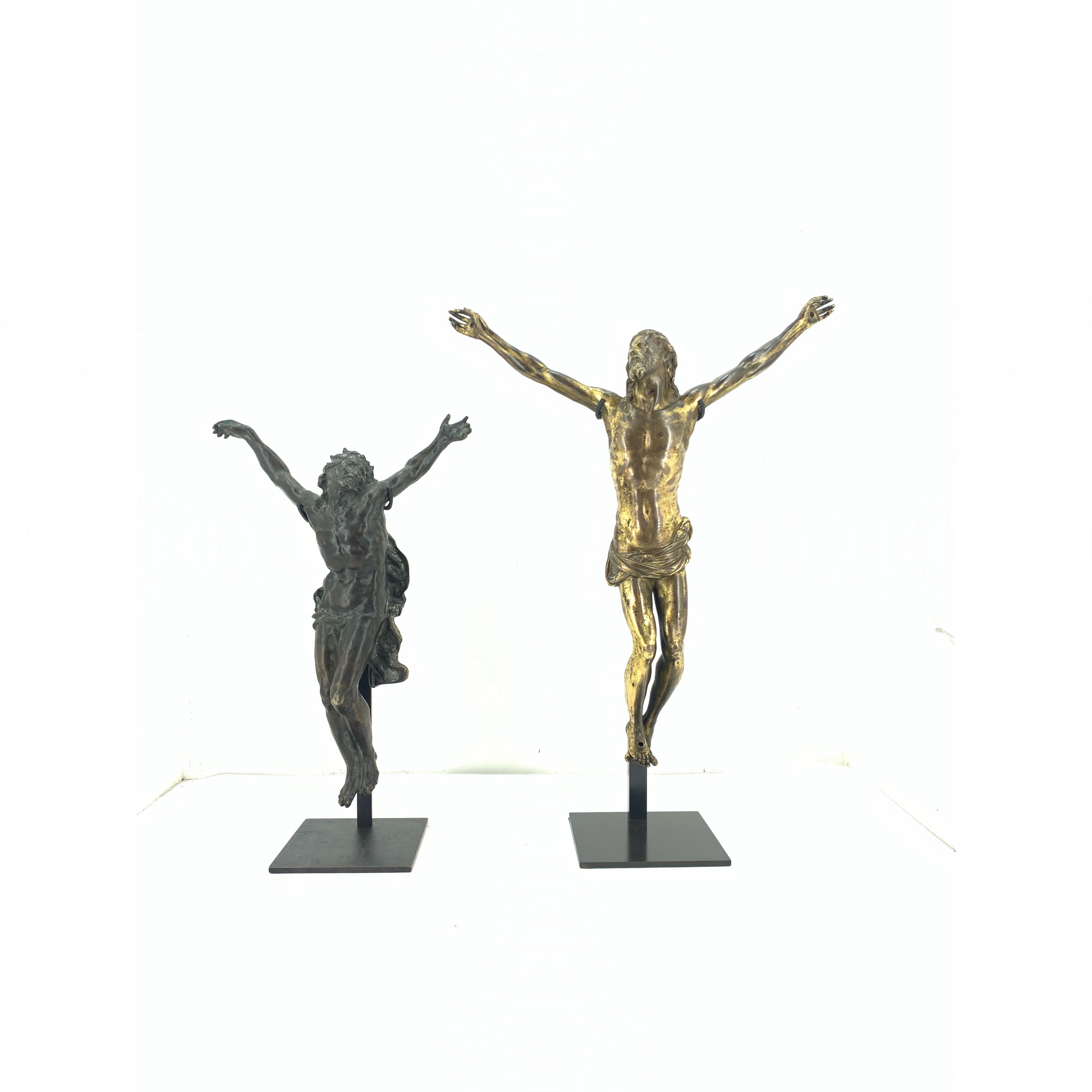 deux christs en croix sur deux socle en acier noir sur fond blanc 