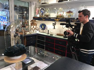 Cameraman de l'mission filmant le globe dans notre atelier boutique